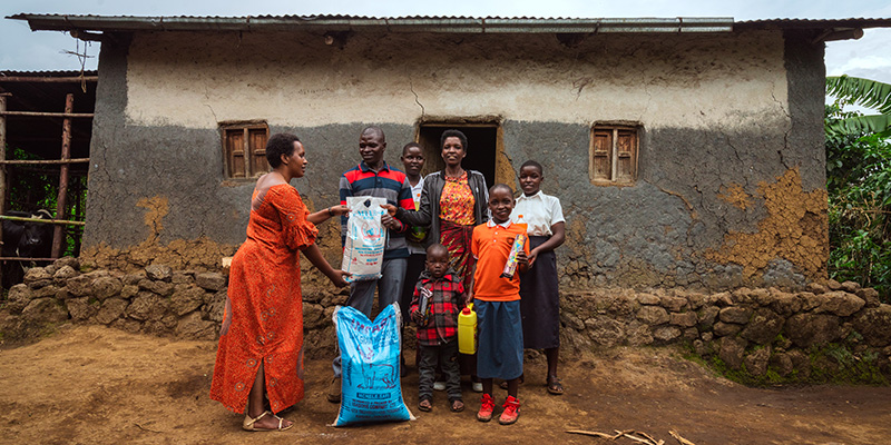 Een familie uit Rwanda krijgt voor hun huis een voedselpakket.