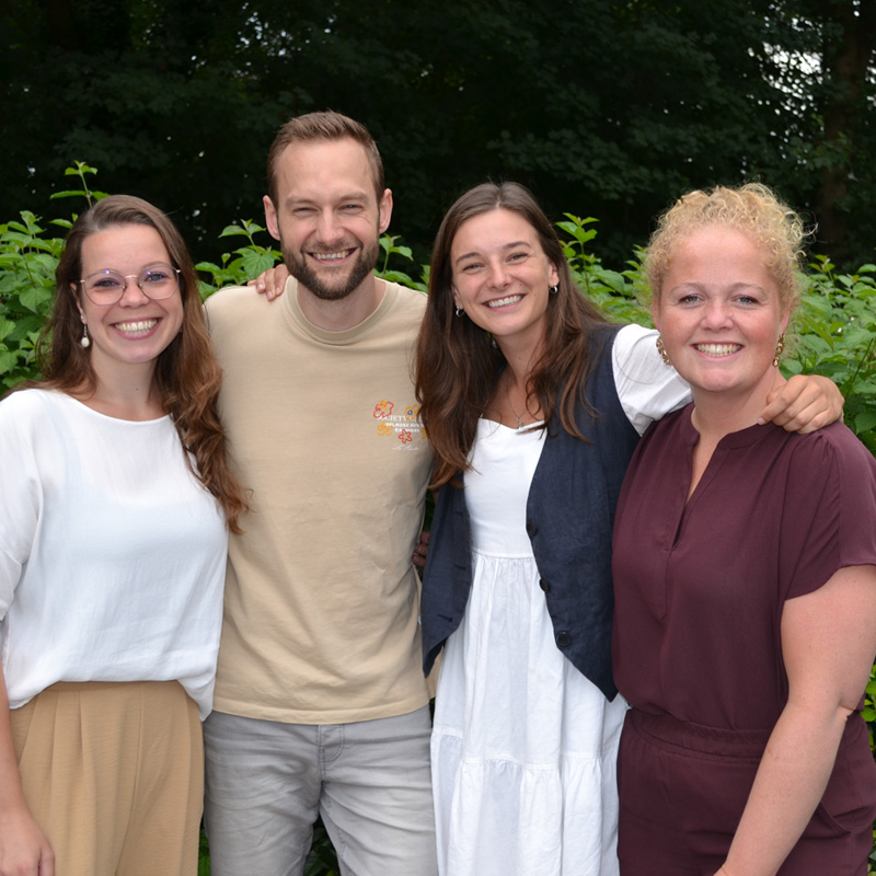 Vier collega's bij Compassion Nederland, Maartje, Benjamin, Ingrid en Elisabeth, die samen team Share vormen en de vrijwilligers coördineren.