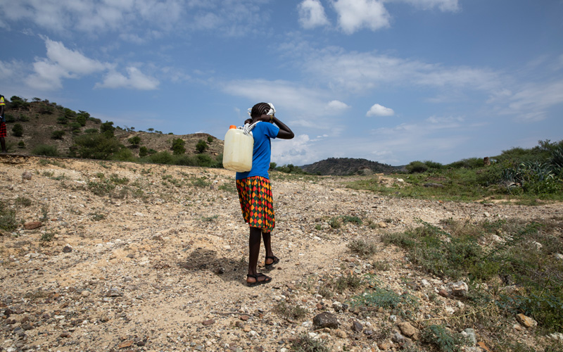 Rehema uit Kenia draagt een jerrycan vol water.