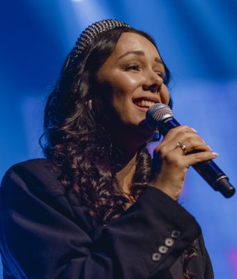 zangeres Rosanne Krijgsman zingt op een podium.