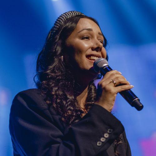 zangeres Rosanne Krijgsman zingt op een podium.