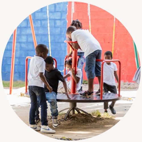 Kinderen in de Dominicaanse Republiek spelen op de nieuwe speeltoestellen bij het Compassion-project.