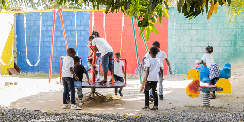 Kinderen in de Dominicaanse Republiek spelen op de nieuwe speeltoestellen bij het Compassion-project.
