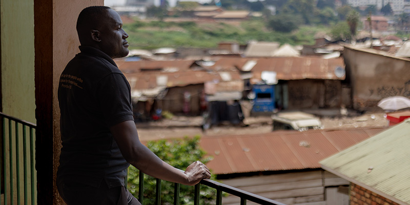 Projectdirecteur Moses uit Uganda kijkt vanaf het project een sloppenwijk in Uganda in.