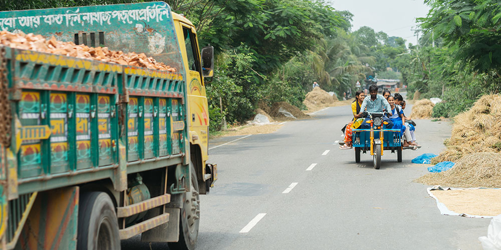 Een nosimon met kinderen rijdt over een snelweg in Bangladesh.