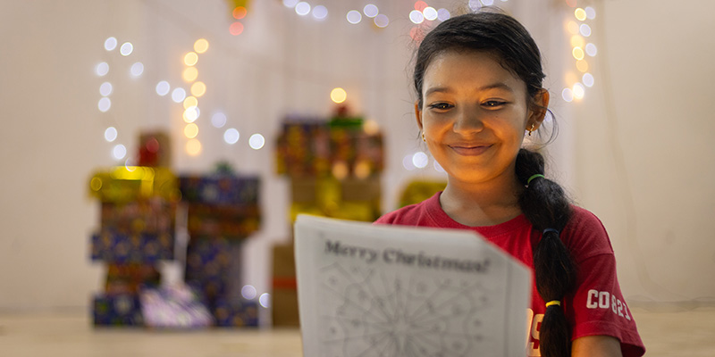 Thalyana uit Colombia leest haar kerstkaart.